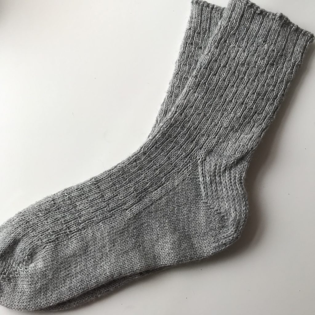 A pair of grey wool knitted socks.